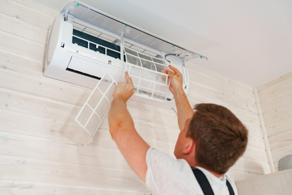 An HVAC technician maintaining an air conditioner
