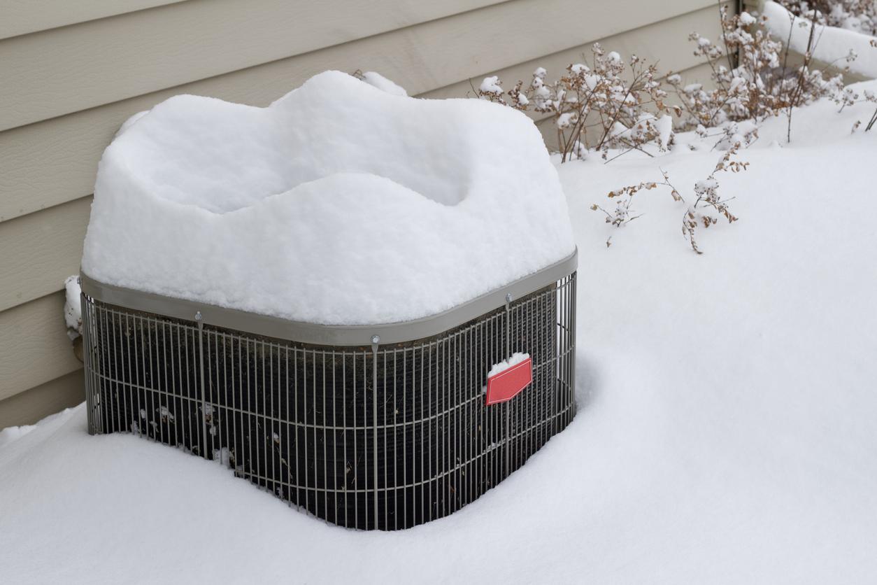 Snow covering an outdoor air conditioner.