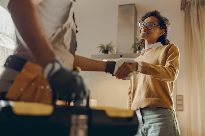 Local HVAC technician shaking hands with happy client